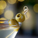 A martini with Belosa Caper Stuffed Queen Olives on a table.