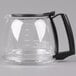 A clear glass coffee pot with a black handle.