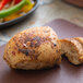 A piece of chicken seasoned with Regal Fajita Seasoning on a cutting board.