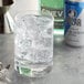 A glass of water with ice cubes and a Polar Club Soda can.