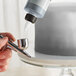 A person using Chefmaster Metallic Silver Airbrush Color to spray a cake using a silver airbrush.