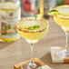 Two glasses of Agalima Organic Spicy Jalapeno Margarita Mix with lime slices and salt rims on a wooden table.