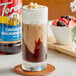 A glass of ice cream with Torani Chocolate Macadamia Nut syrup and chocolate topping.