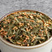 A bowl of green leaves and nuts.