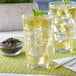 A glass of Bossen jasmine green loose leaf tea with ice and a mint leaf on top.