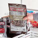 A hand holding a box of Wild Bill's hickory-smoked beef jerky.
