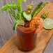 A glass of Chincoteague Bloody Mary Clam and Tomato Juice Mix with shrimp and vegetables.