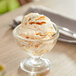 A glass dish filled with Oringer caramel variegate over ice cream.