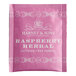 A pink and white Harney & Sons Raspberry Herbal Tea packet.