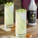 Two glasses of cucumber juice on a table.