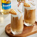 Two glasses of brown liquid with a Torani Shortbread flavored syrup drink with cookies on top.