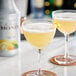A glass of yellow liquid with a Monin Yuzu Fruit Puree cocktail garnish.