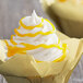 A cupcake with yellow swirls on top of white frosting.