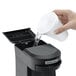 A person pouring water into a Hamilton Beach single serving pod coffee maker.