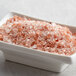 A bowl of Regal Coarse Grain Pink Himalayan Salt on a counter.