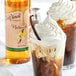 A drink in a glass with a vanilla bean and DaVinci Gourmet Vanilla Flavoring Syrup.