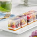 A row of fruit jelly cubes on a plate.