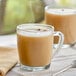 A table with two glass mugs of brown David Rio Tiger Spice Chai tea latte.