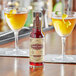 A bottle of Scrappy's Chocolate Bitters next to a glass of yellow liquid.