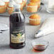 Regal Gourmet Pure Vanilla Extract next to a bowl of vanilla extract and cupcakes.