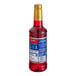A close up of a Torani Dragon Fruit flavoring syrup bottle filled with red liquid.