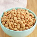 A bowl of Callebaut Gold Caramelized White Chocolate Callets on a table.