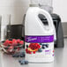 A white jug with a purple Torani label filled with a blue liquid.