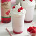 Two milkshakes with DaVinci Gourmet Raspberry syrup, whipped cream, and raspberries on top.