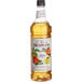 A bottle of Monin apple fruit syrup.