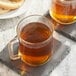 Two Twinings Pure Peppermint herbal tea K-Cups in glass mugs on a stone coaster.