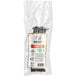 A white bag with black text and red and white labels containing black vanilla beans.