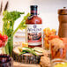 A bottle of Agalima Organic Bloody Mary Mix on a table with vegetables.