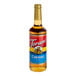 A close-up of a Torani Caramel Flavoring Syrup bottle with a label.