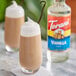 Two glasses of vanilla milkshakes with whipped cream on top using Torani vanilla syrup.