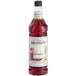 A Monin bottle of grenadine syrup with red liquid inside.