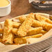 Breaded garlic and onion pickle spears in a basket with ranch dressing.