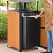 A square outdoor trash can with a covered top, featuring steel and wood composite panels.