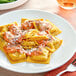 A plate of Seviroli Butternut Squash Square Ravioli with sauce and a fork.