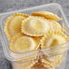A white plastic container of Seviroli Shrimp and Roasted Garlic Hexagon Ravioli on a table.