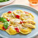 A plate of Seviroli shrimp and roasted garlic ravioli with cheese and basil.