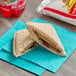 A SunWise strawberry crustless sandwich on a blue napkin.