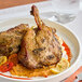 A plate of Maple Leaf Farms fully cooked duck leg confit on a table.