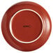 An Acopa Sedona orange porcelain plate with white trim.