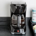 A black Proctor Silex coffee maker on a counter.