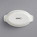 A white oval Acopa porcelain casserole dish.
