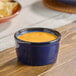 A small blue porcelain ramekin filled with a creamy orange sauce.