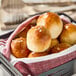A basket filled with Pennant Parker House style white dinner rolls.
