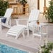 A white Lancaster Table & Seating Adirondack table on a patio with a drink on it.