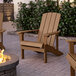 Two brown Lancaster Table & Seating Adirondack chairs on a brick patio.