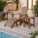 A brown Lancaster Table & Seating high impact polystyrene Adirondack chair on an outdoor patio.